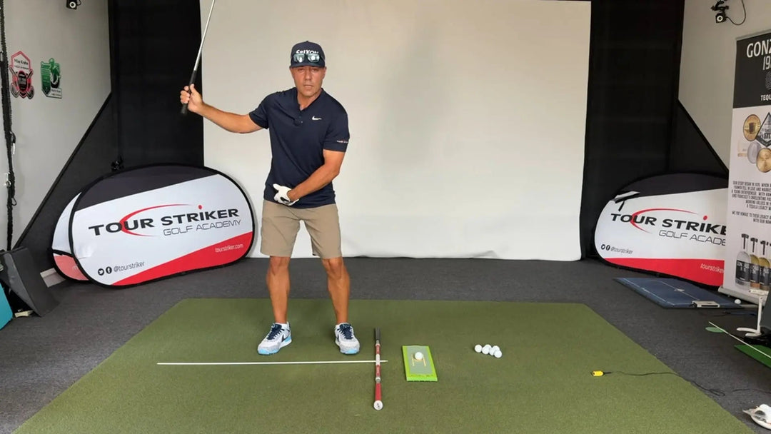 Golfer practicing iron swing indoors to stop hitting fat shots using Divot Board training aids