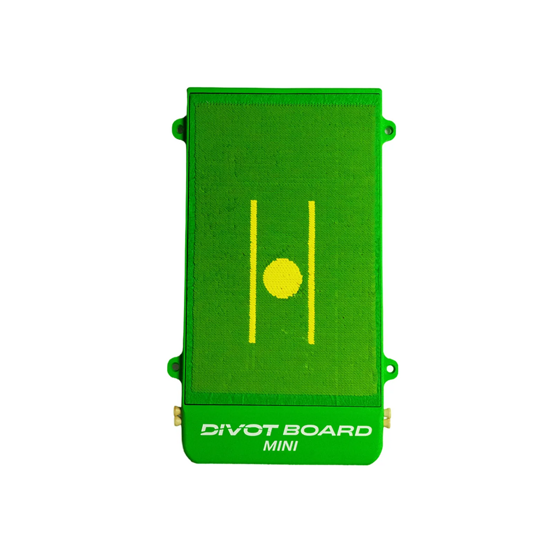 Divot Board MINI seen from above: green turf hitting face with two yellow alignment lines and a yellow ball spot