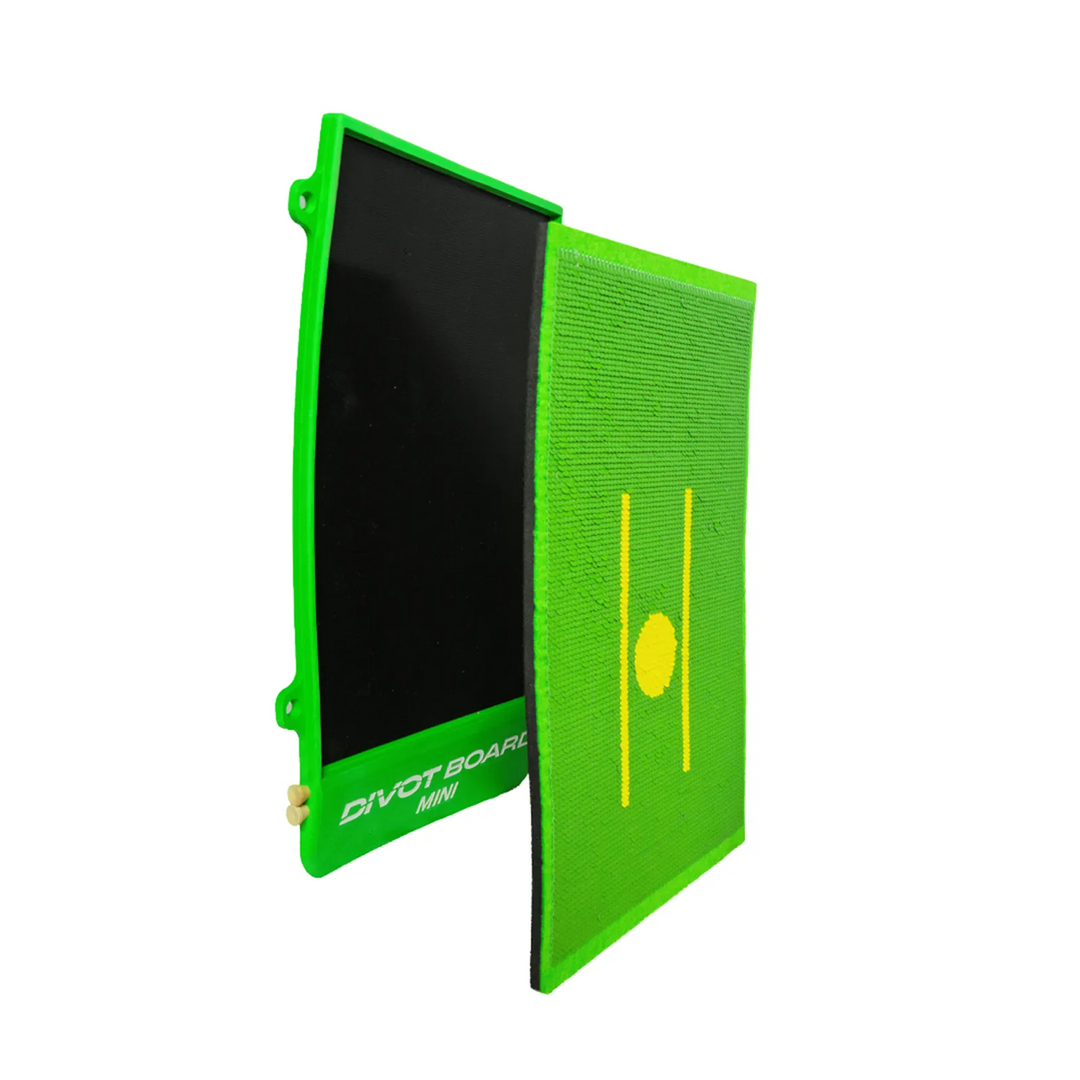 Divot Board MINI with its turf pad lifted off and stood upright beside the green base, exposing the black foam layer