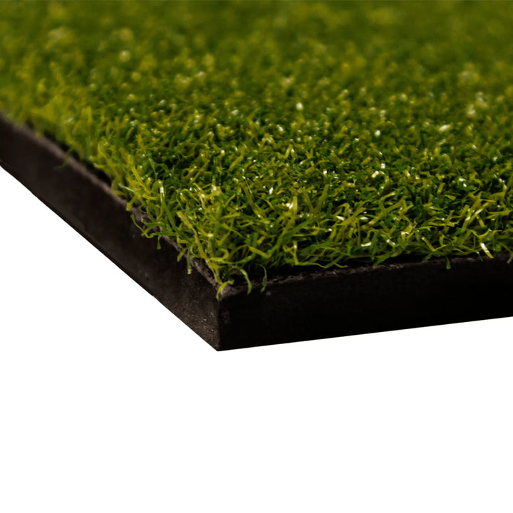 Corner close-up of the Divot Board Turf Mat, dense green turf pile on a thick black rubber base